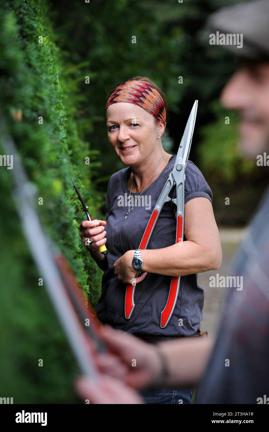 A female topiary artist working on a Yew hedge, UK Stock Photo