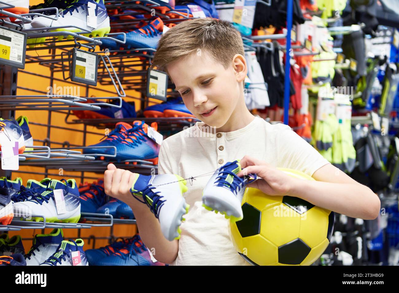 Boy with a ball and boots in a football clothing store Stock Photo Alamy