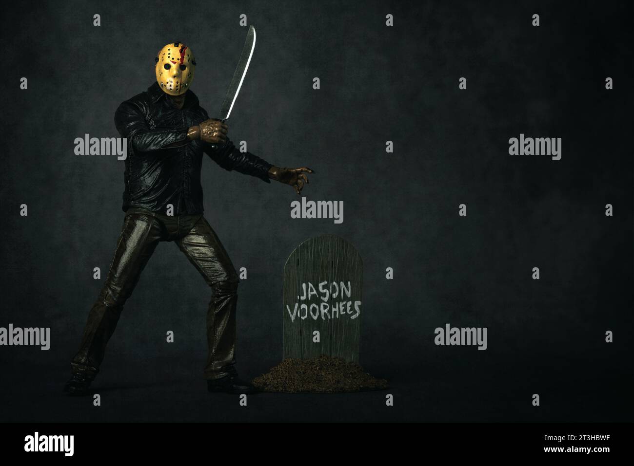 Figure of Jason Voorhees with machete main character of the film series Friday the 13th over grey background. Illustrative editorial Stock Photo