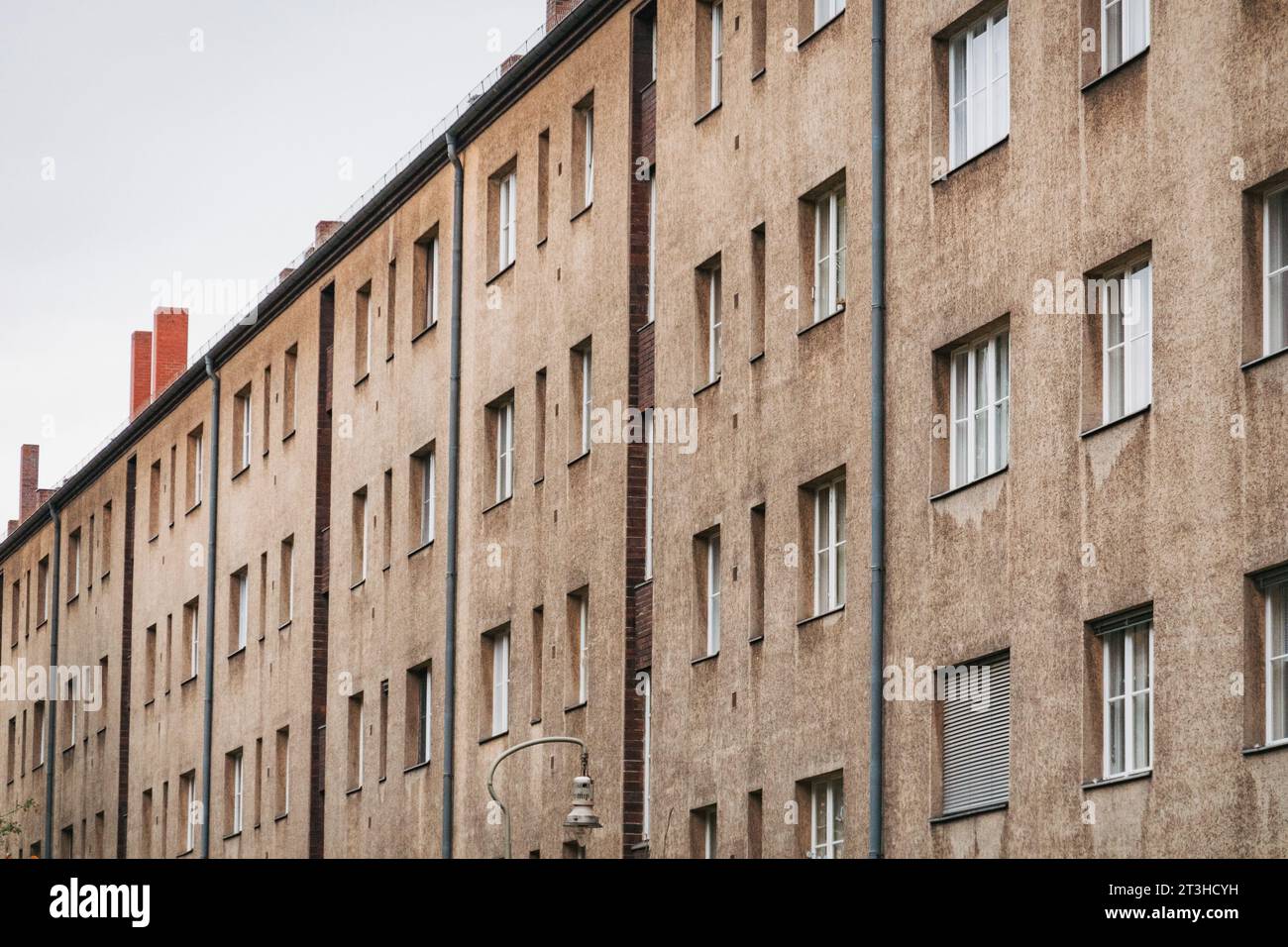 rows of windows on a long grey apartment block in Berlin, Germany Stock Photo
