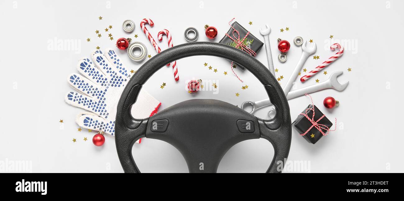 Steering wheel with Christmas decor and tools on light background Stock Photo