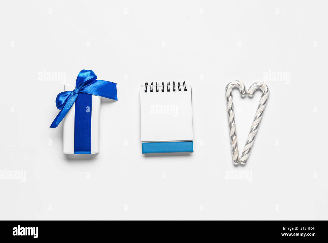 Blank paper calendar with gift box and candy canes on grey background ...