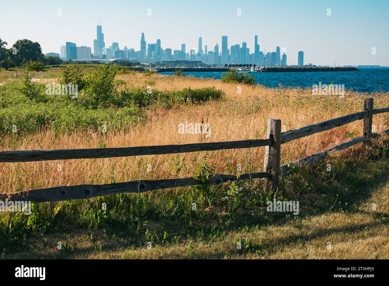 a wooden fence separates a thicket at Burnham Park on the shores of Lake Michigan, Chicago, United States Stock Photo