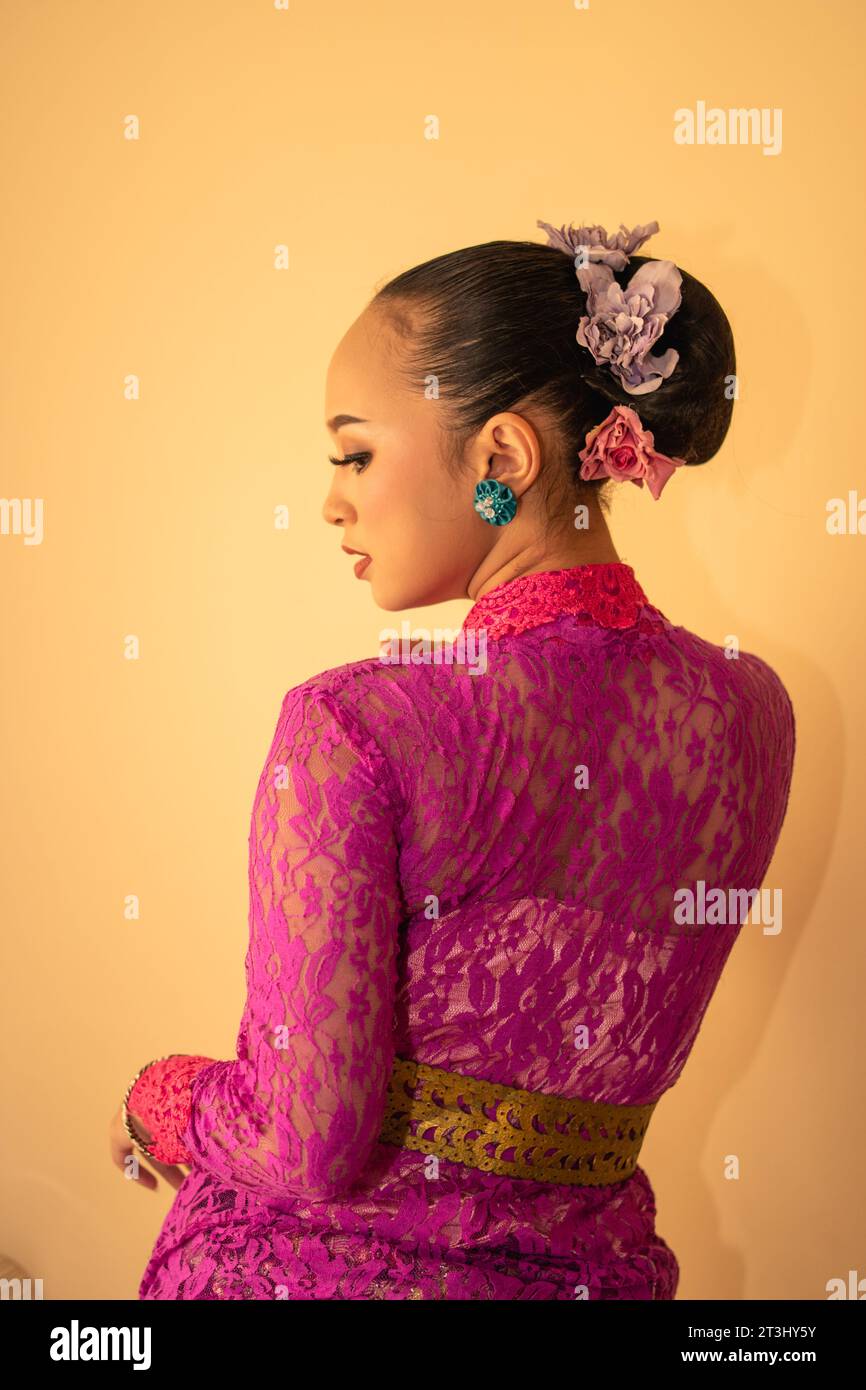 Balinese bride wearing the pink wedding dress before the ceremony has started inside the temple Stock Photo