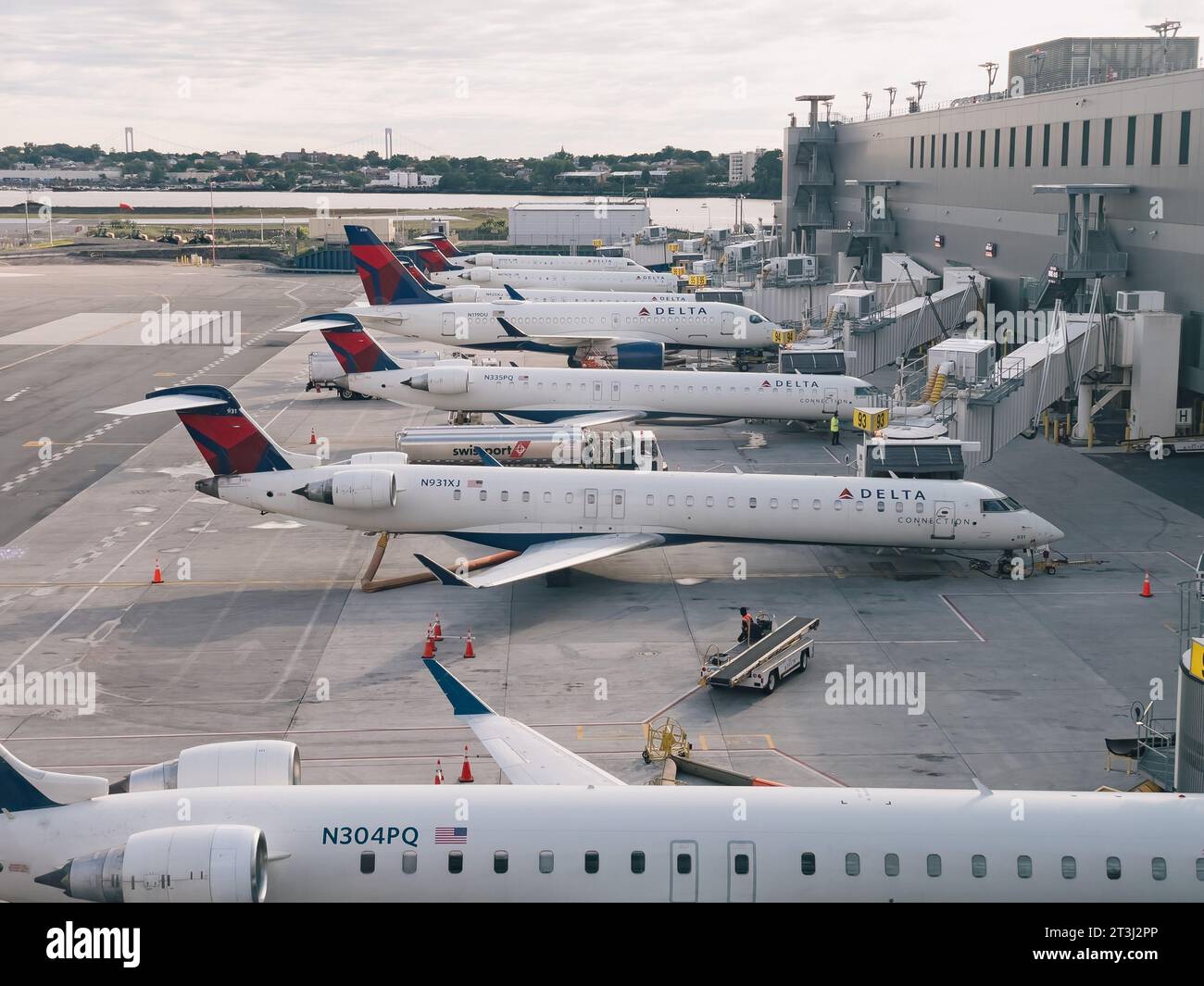 a row of Delta Air Lines regional jets on gates at La Guardia Airport one spring morning Stock Photo