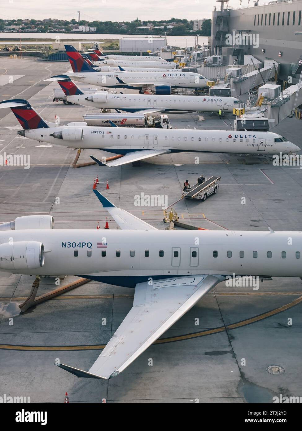 a row of Delta Air Lines regional jets on gates at La Guardia Airport one spring morning Stock Photo