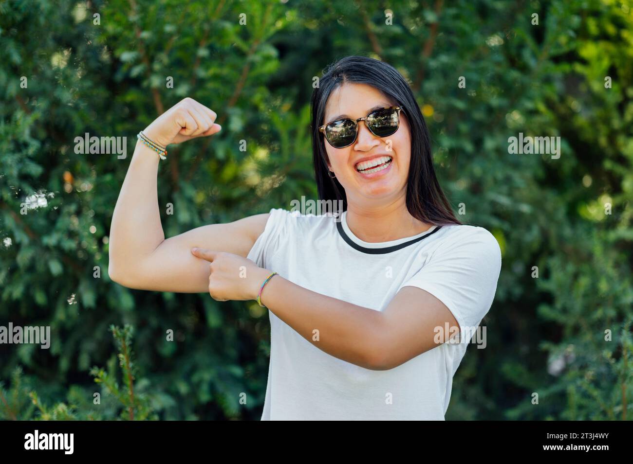 Young woman pointing to her arm .Power woman Stock Photo