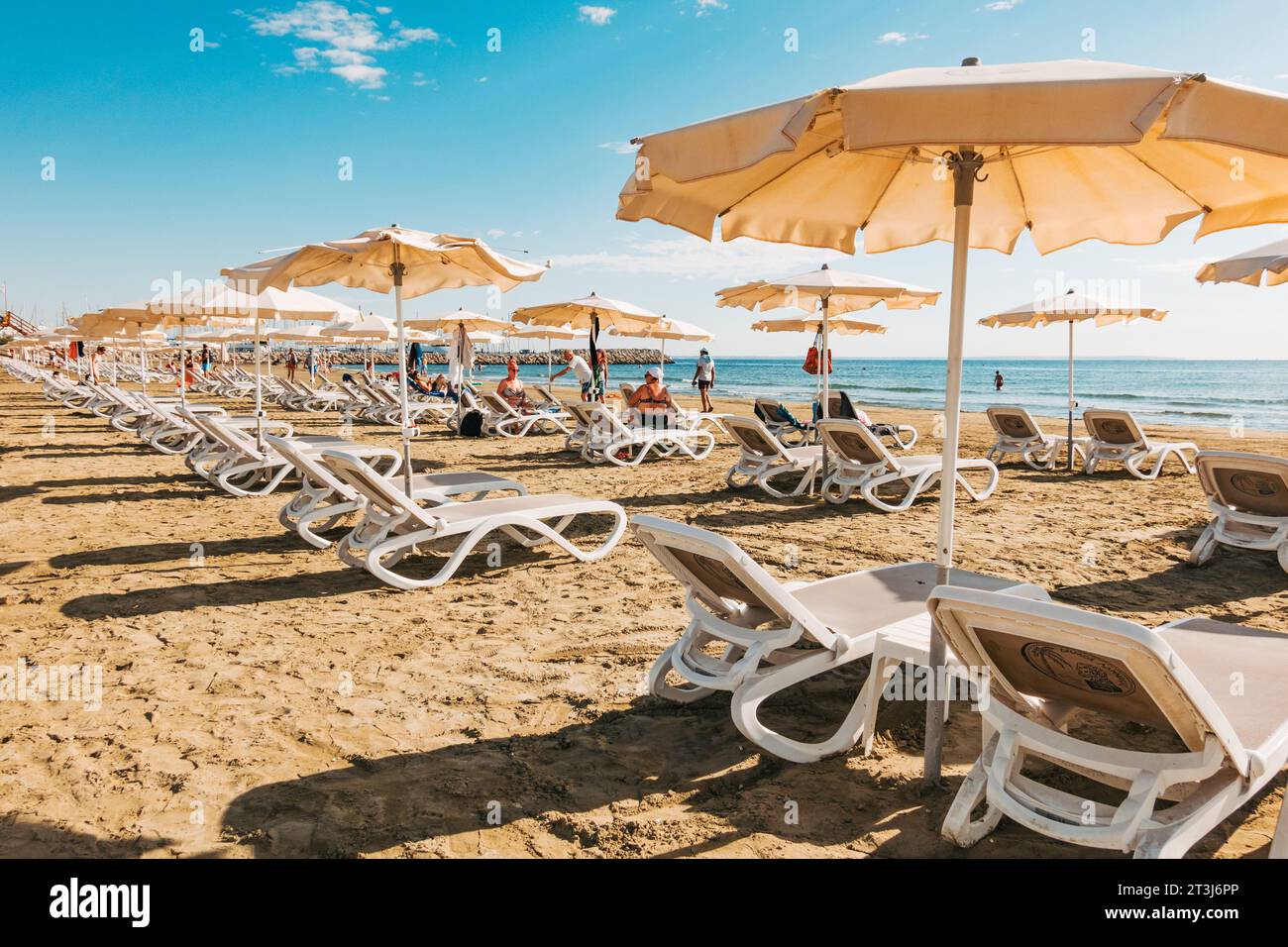 Sun lounger seats and umbrellas ready for customers at Finikoudes Beach, Larnaca, Cyprus Stock Photo