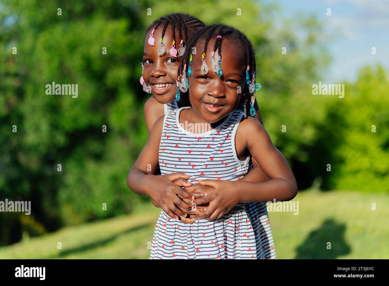 Two little african american girls hugging in the park Stock Photo - Alamy