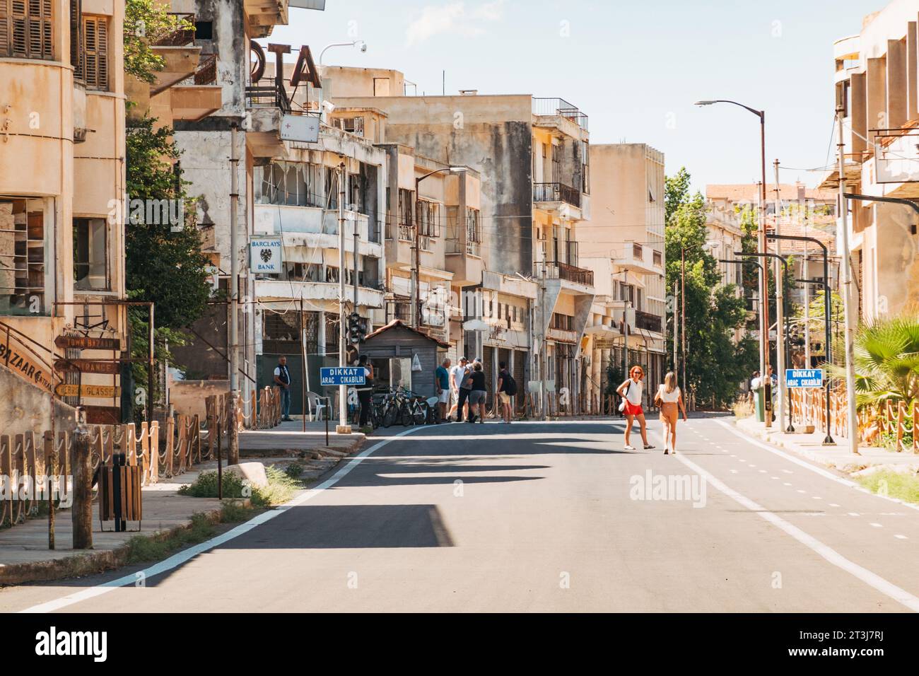 Tourists walk along a new road between abandoned buildings in the ghost town of Varosha, Northern Cyprus, which re-opened to the public in 2020 Stock Photo