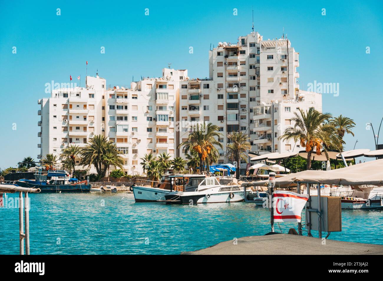 apartment blocks at a marina in Famagusta, Northern Cyprus. A Turkish Cypriot flag is seen flying on the marina Stock Photo