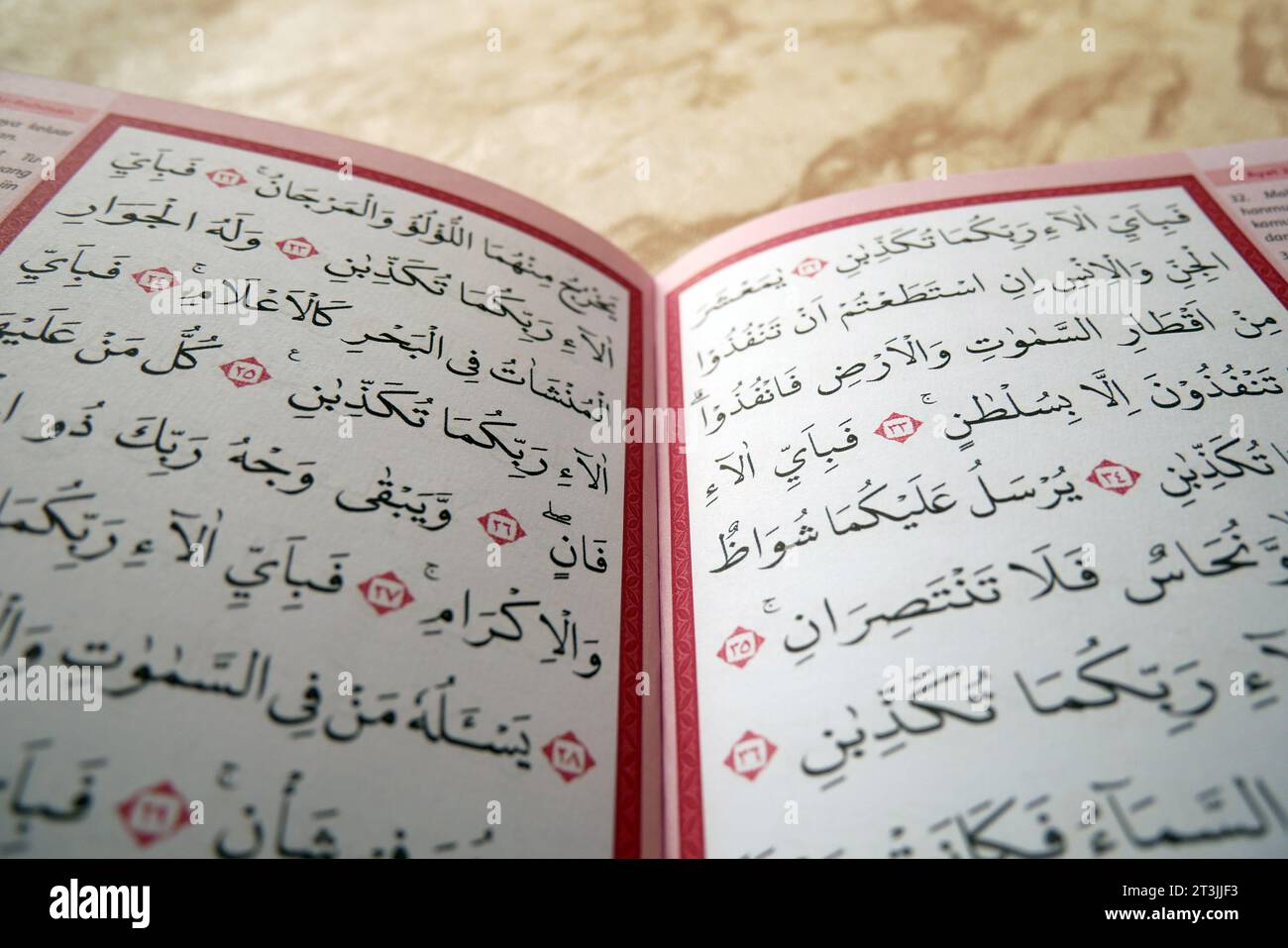Man's hand flips open page of Quran on black background. The Quran is the holy book of Islam for Muslims. Stock Photo