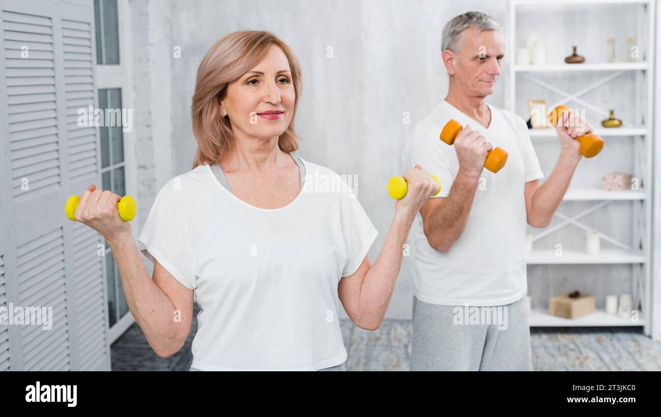 Happy senior couple exercising using dumbbells Stock Photo
