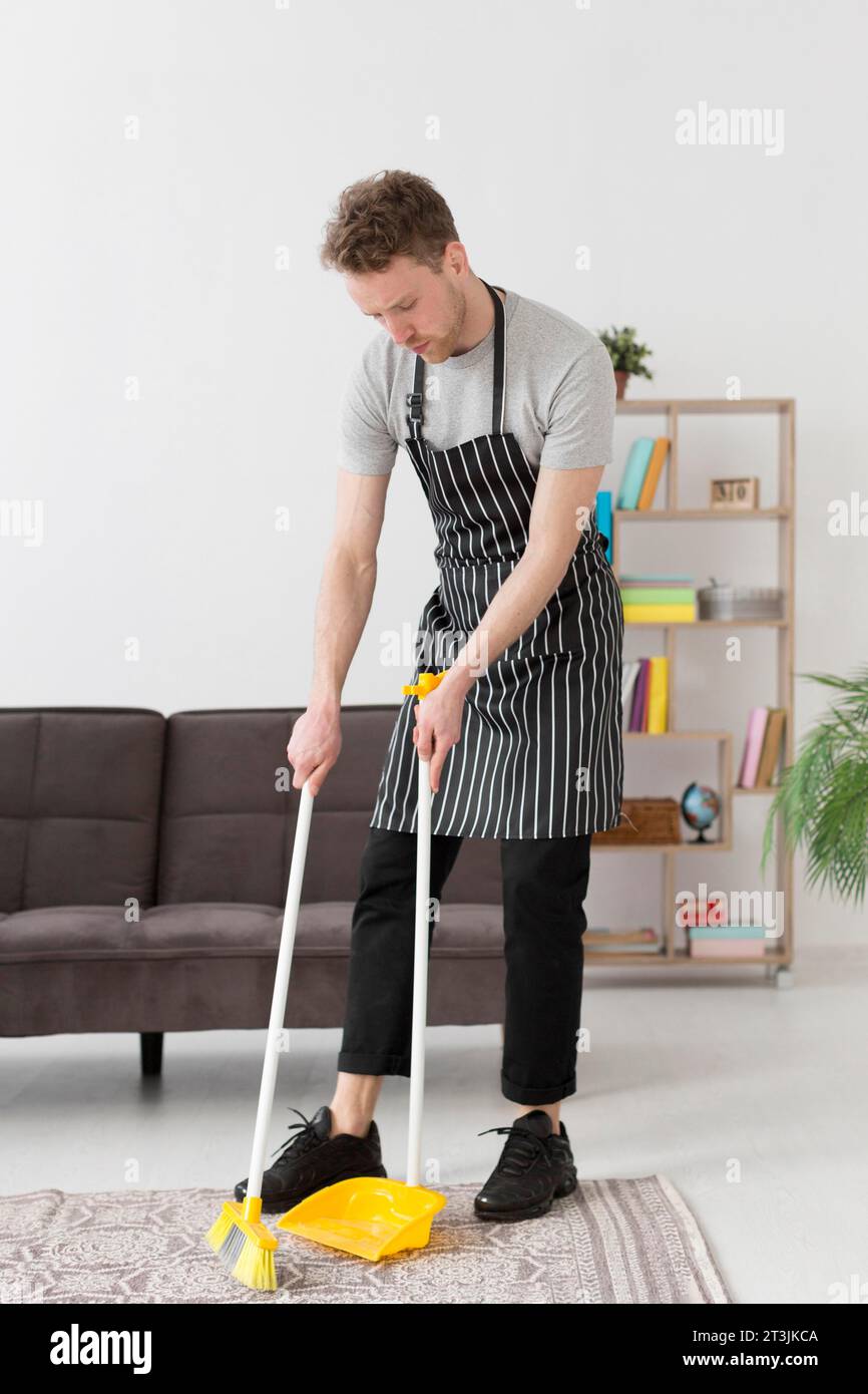 High angle man brooming floor Stock Photo