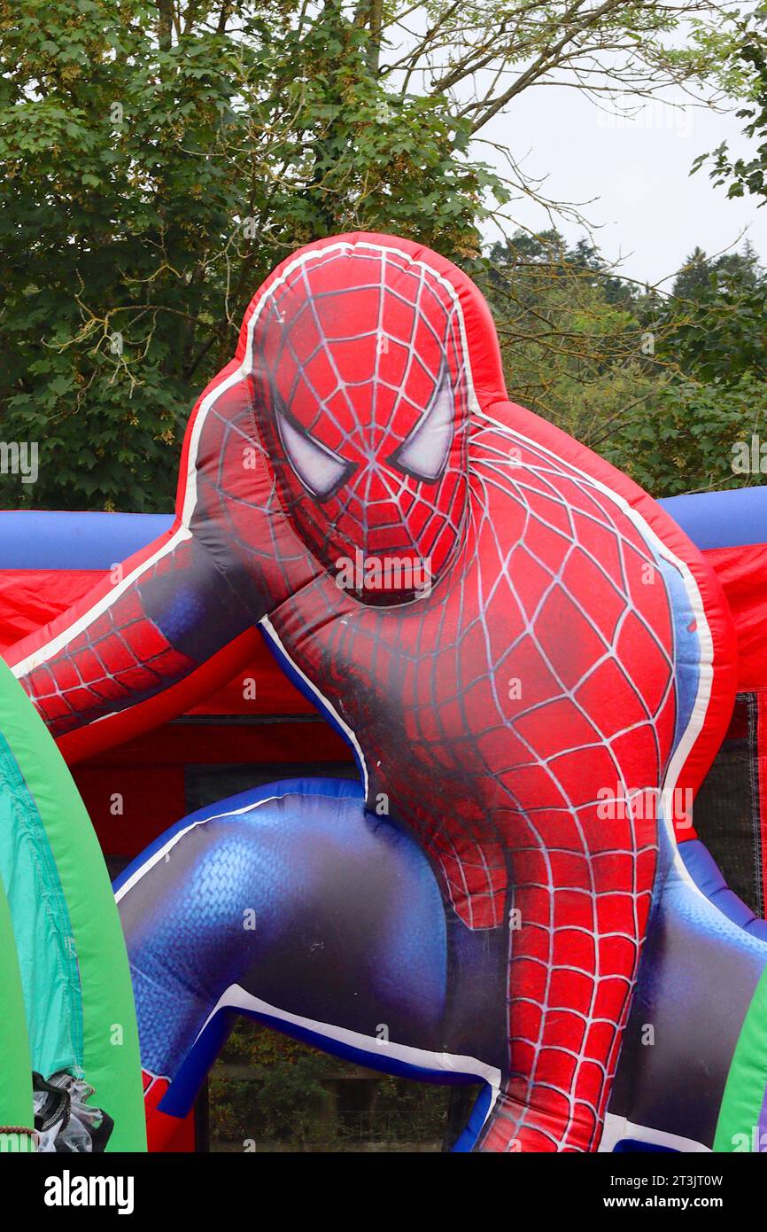 Spiderman, larger than life super hero featured on the front wall of an inflatable themed bouncy castle in a childrens play area at a local food show. Stock Photo