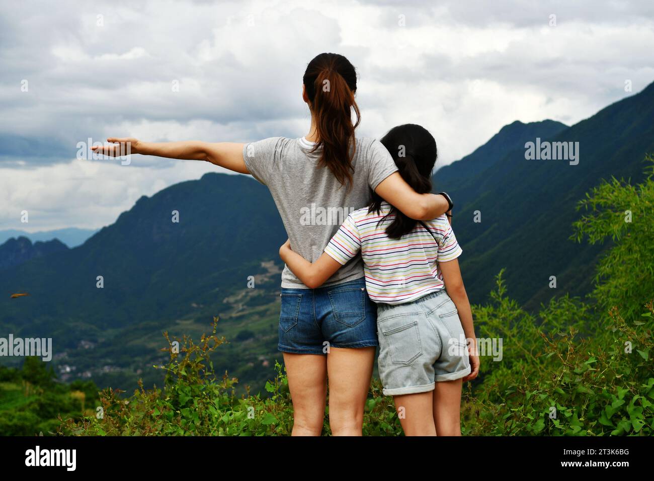 Photo of mother and daughter standing in front of mountains Stock Photo