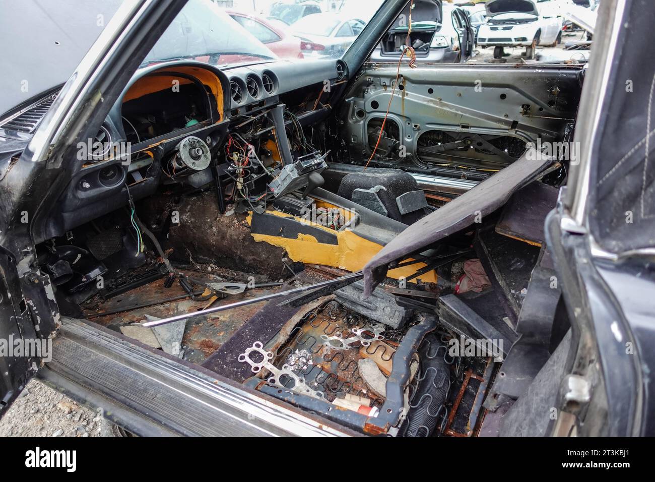 Inside of a car with seats, steering wheel and other parts removed at a