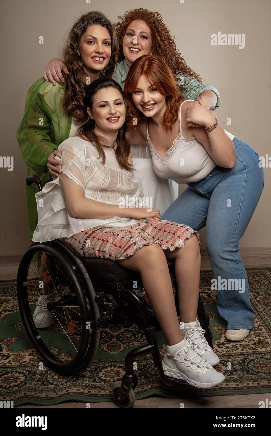 Four women celebrate their unique beauty and friendship in a heartfelt portrait. From freckles, a gap-toothed smile, to curves, to the strength of a w Stock Photo