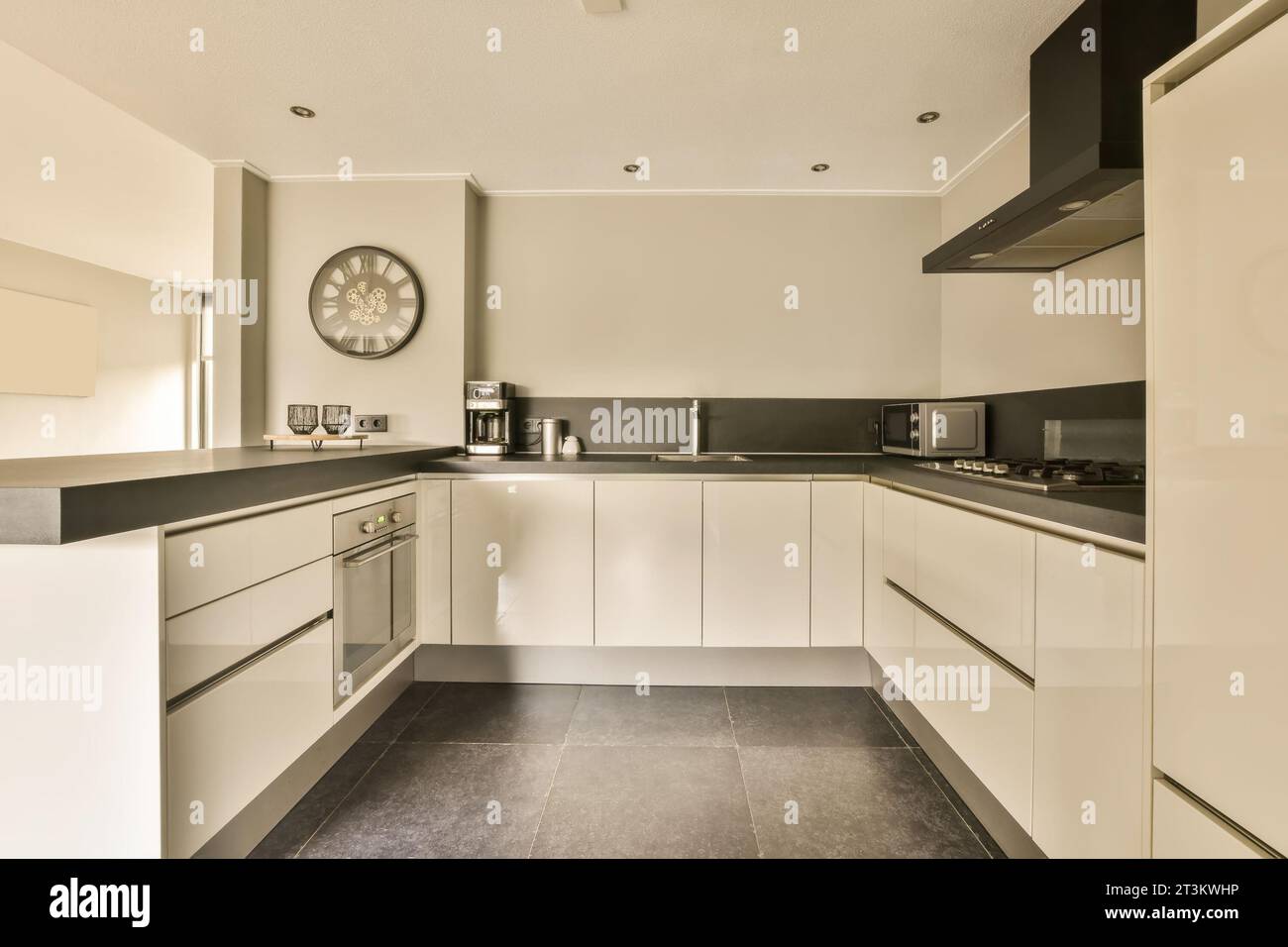 a kitchen with black counter tops and white cupboards on the wall ...