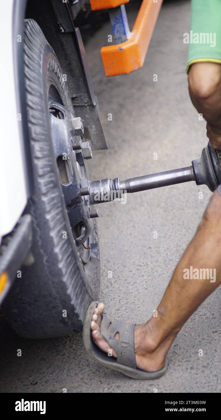 install the nuts on the truck wheels using mechanical tools Stock Photo
