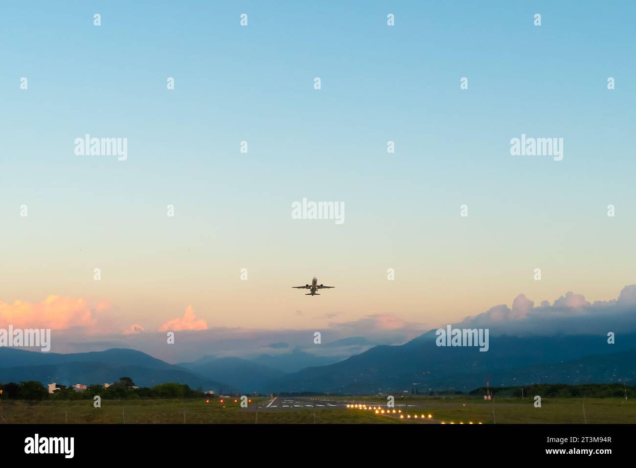 White passenger plane takes off against a beautiful sky with golden ...