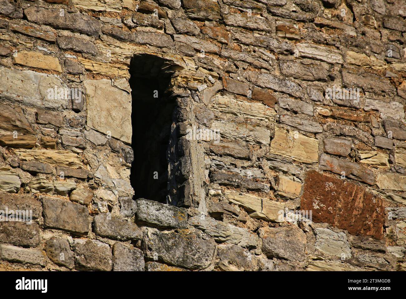 Loophole of a medieval watchtower in sunlight. Stock Photo