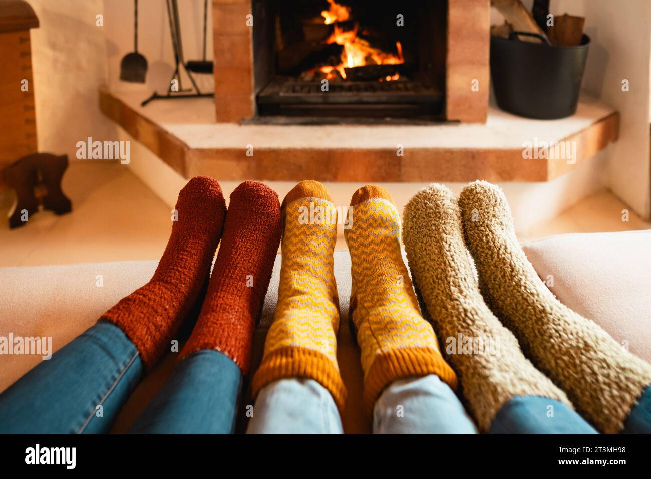 Closeup legs of women wearing warm socks in front of fireplace - Winter season concept Stock Photo