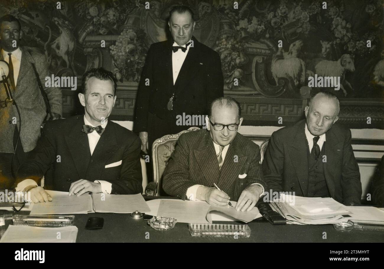 French politician Edgar Faure signs the Franco-Tunisian Agreement, his Minister Pierre July, and General Boyer de Latour, Paris, France 1955 Stock Photo