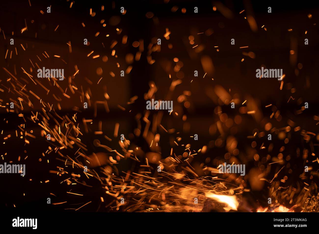 The texture of the fire. Sparks in the dark. Flames on a black background. Small sparks Stock