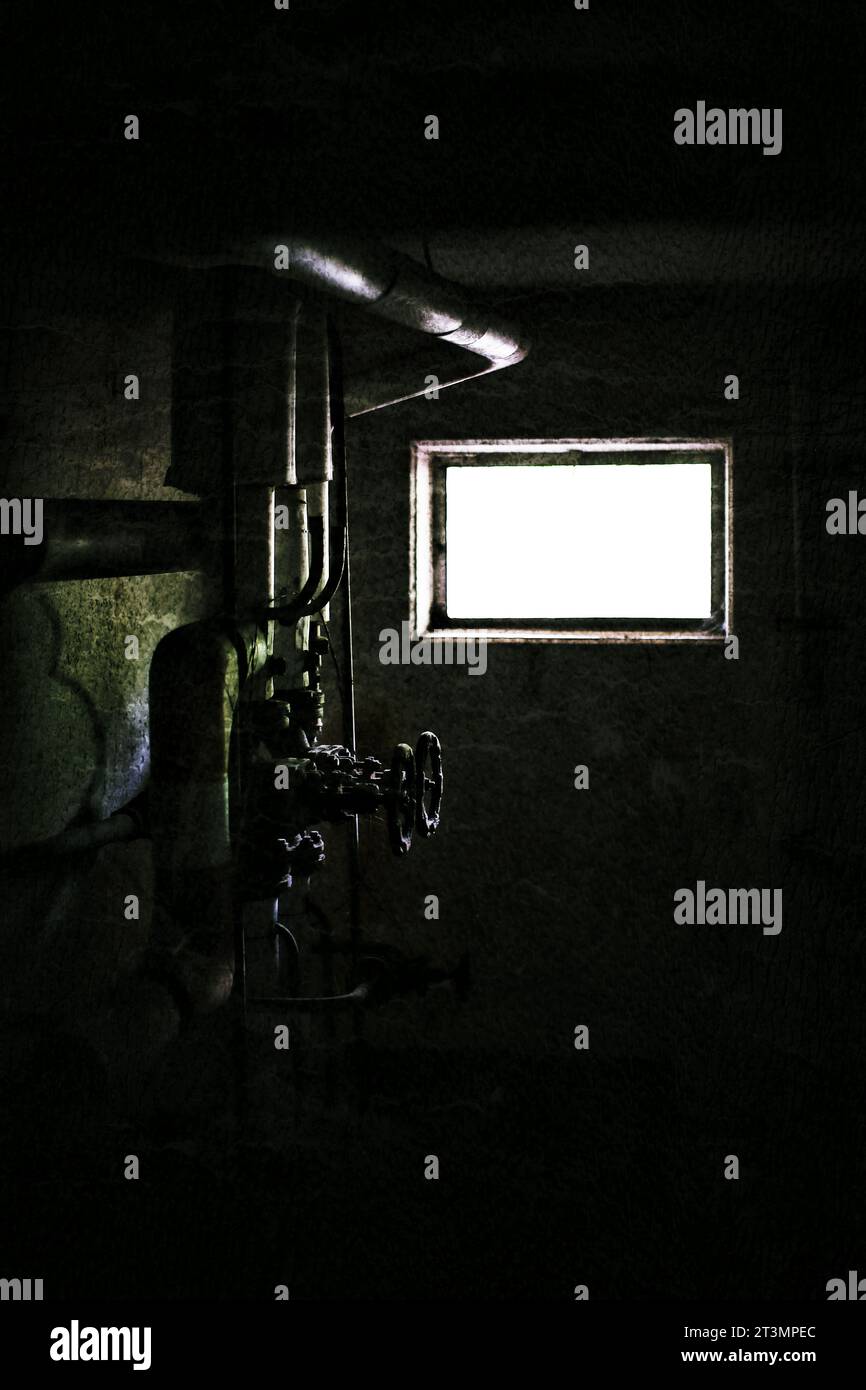 Grungy image of pipes and valves in dark basement. Stock Photo
