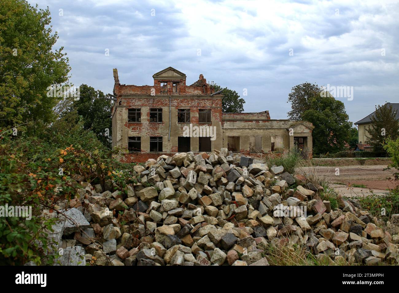 Ruins of an old residential building with heap of stones. Stock Photo