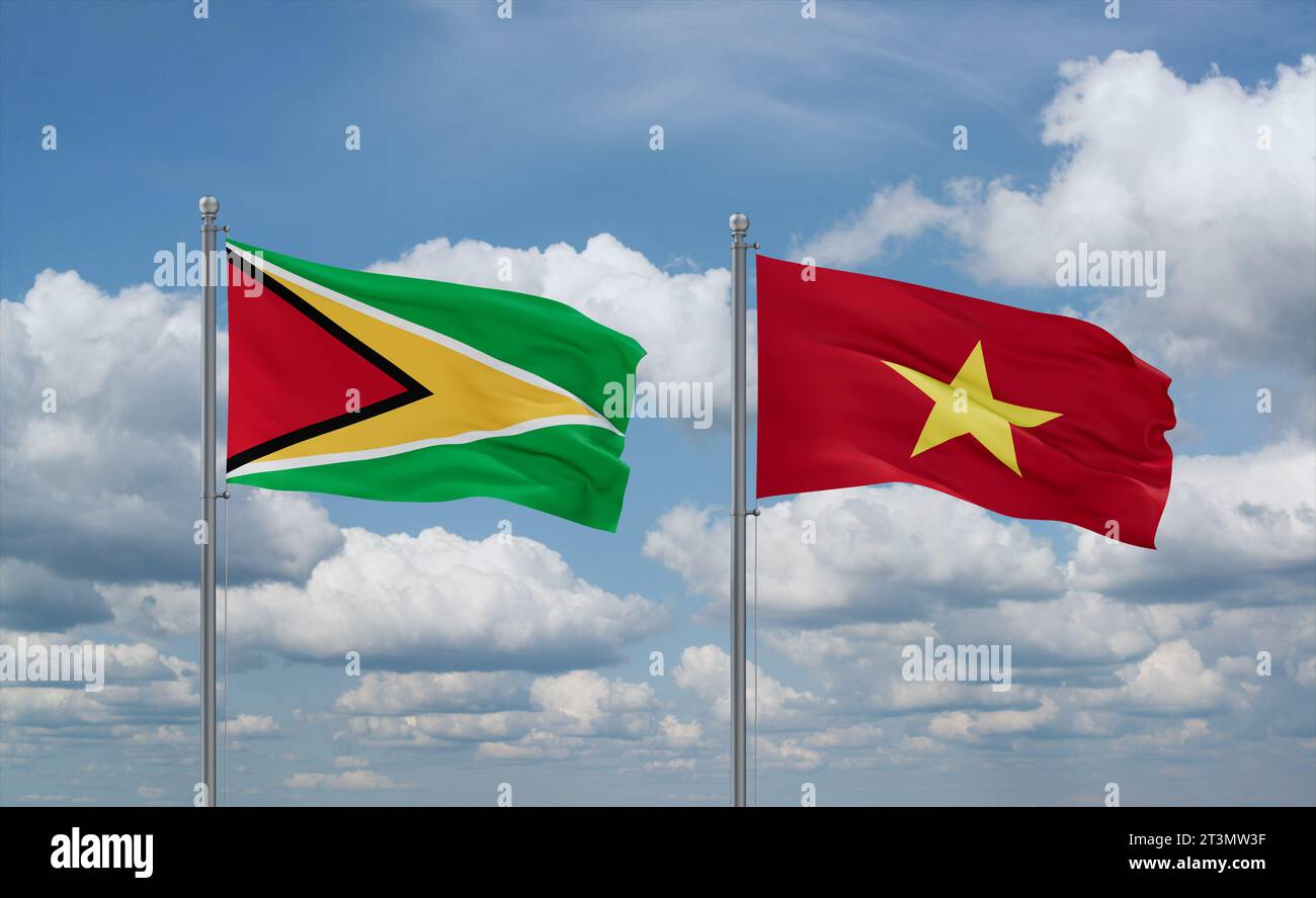 Vietnam and Guyana flags waving together in the wind on blue cloudy sky Stock Photo