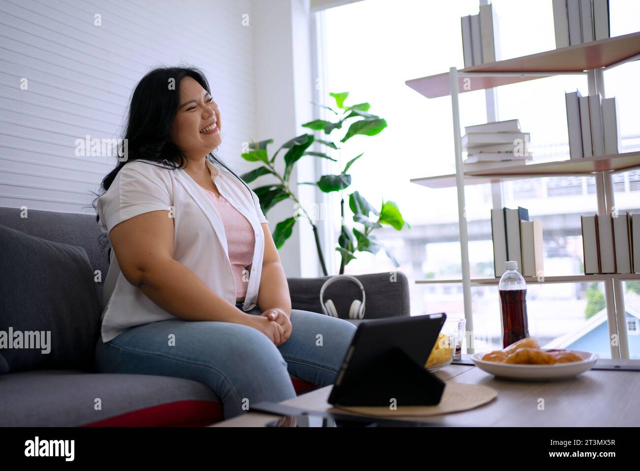 Plus size woman is eating donut. Health care and lifestyle concept. Stock Photo
