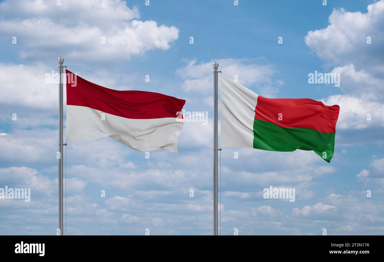 Madagascar and Indonesia and Bali flags waving together on blue cloudy ...