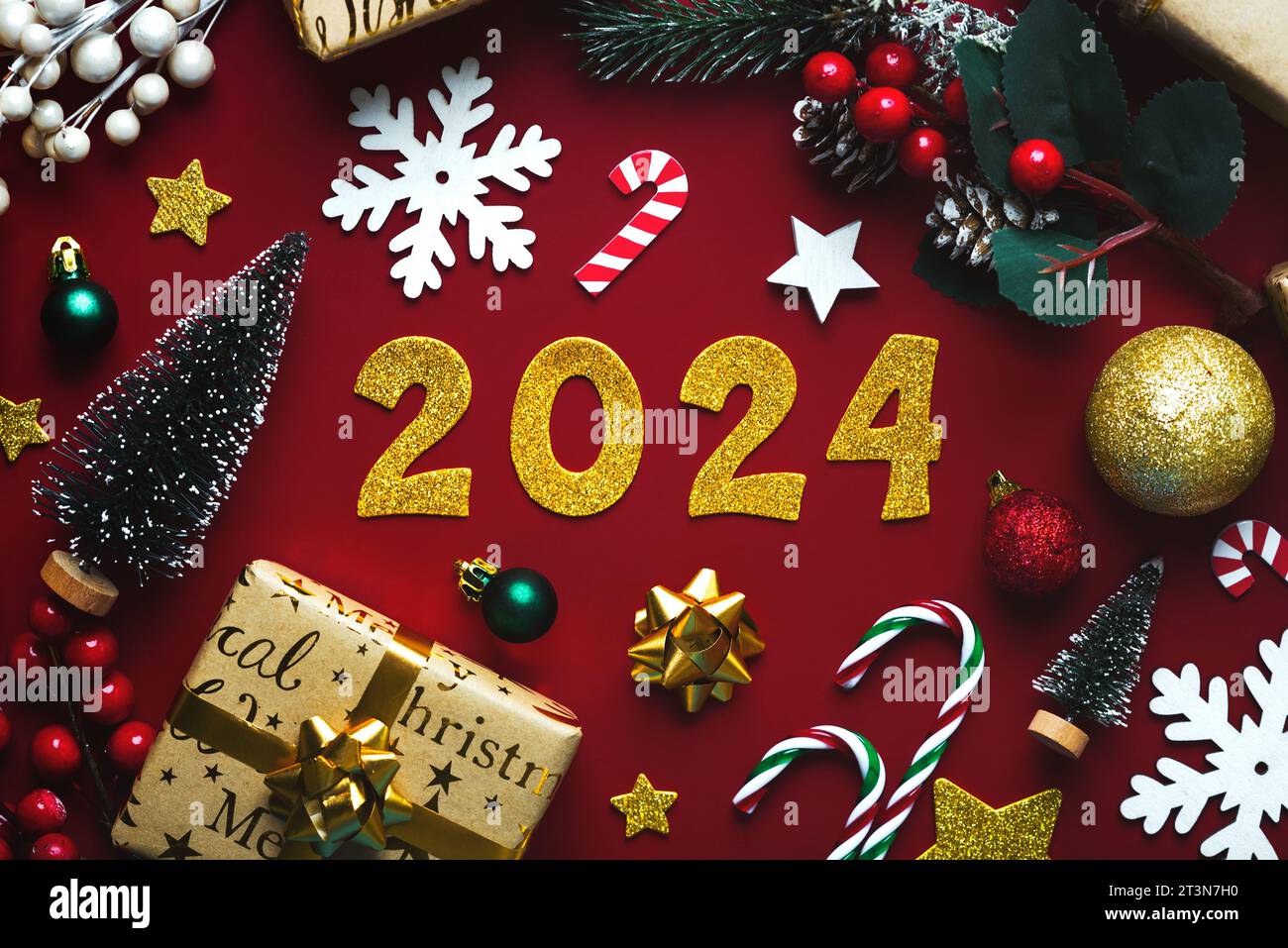 Happy new year 2024. Top view christmas ornament and golden numbers with the number 2024 over red background. New Years Eve celebration concept backgr Stock Photo