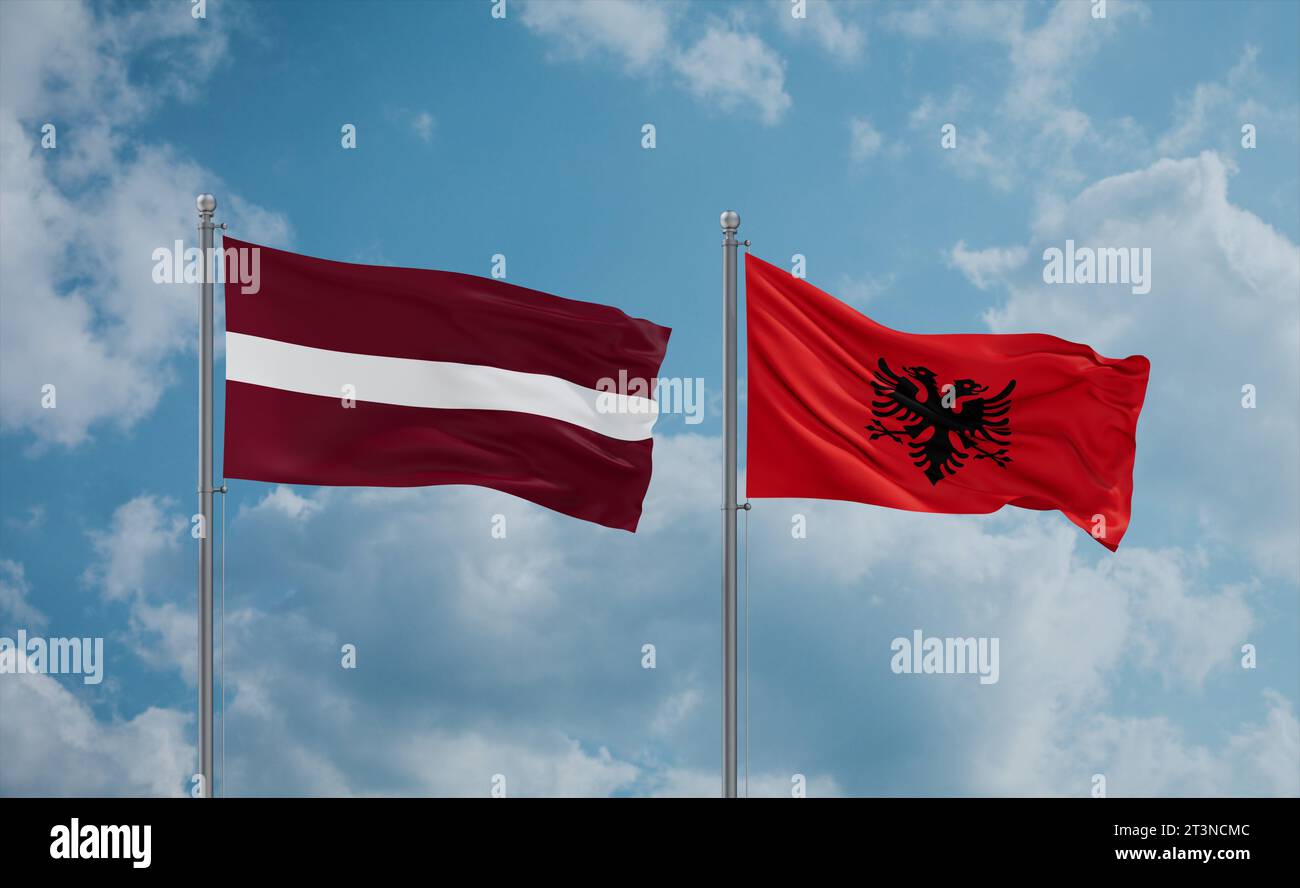Latvia and Albania flags waving together in the wind on blue cloudy sky ...