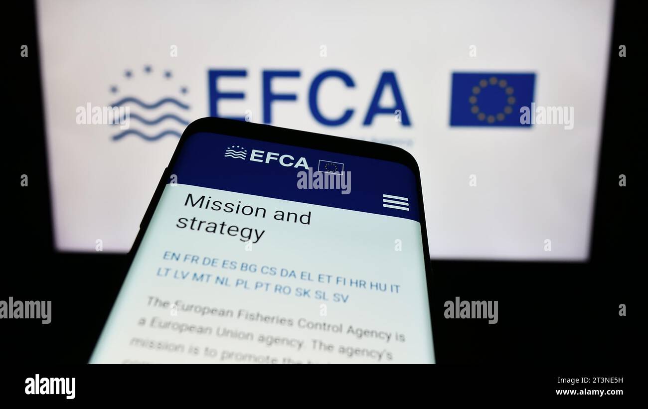 Mobile phone with webpage of EU institution European Fisheries Control Agency (EFCA) in front of logo. Focus on top-left of phone display. Stock Photo