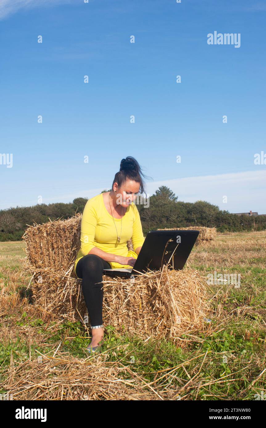 Senior female working on laptop outdoors - John Gollop Stock Photo