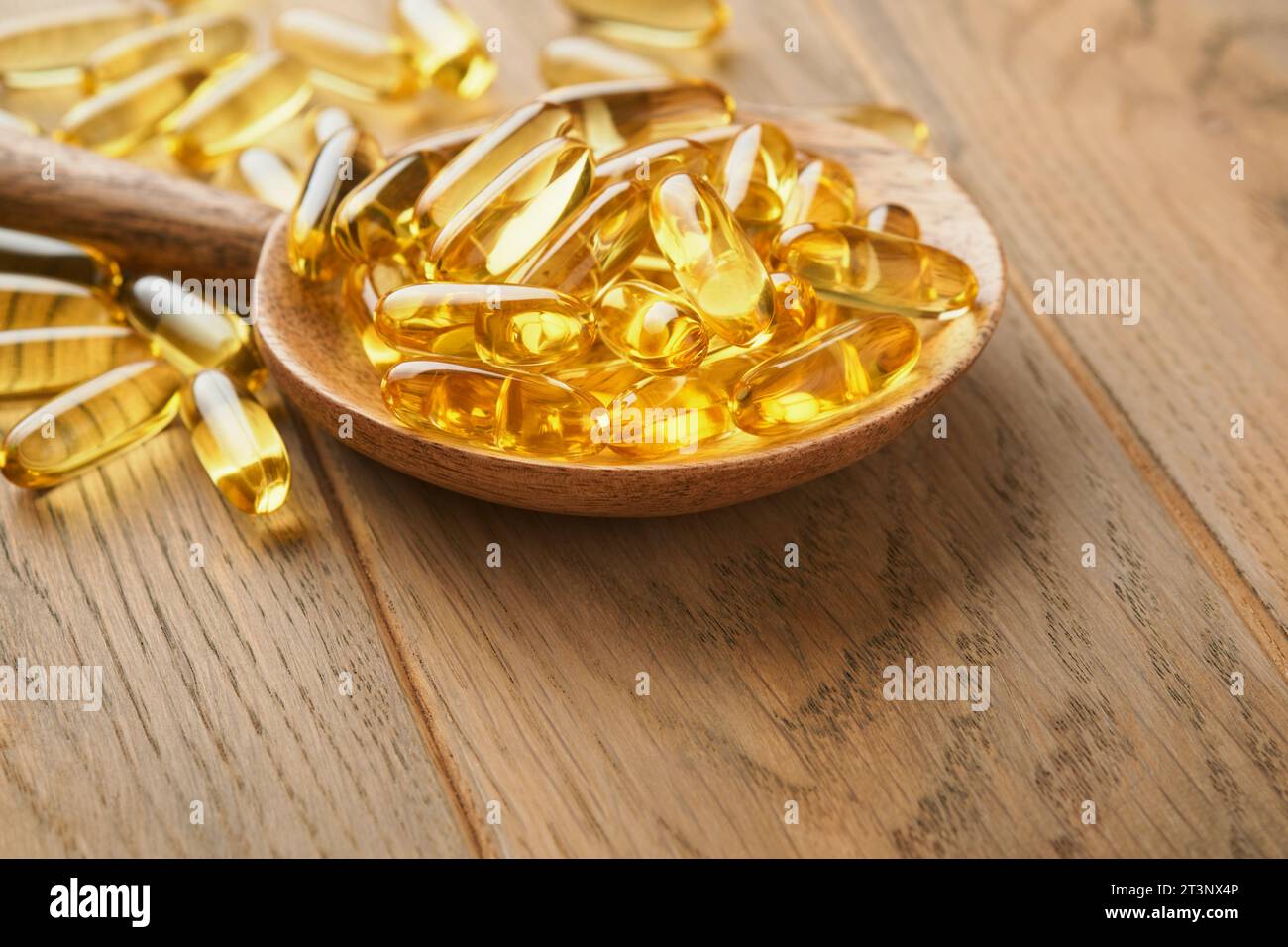 Close up capsules with Vitamin D, E or Omega 3,6,9 fatty acids in bottle on old wooden backgrounds. Food supplement oil filled fish oil. Natural suppl Stock Photo
