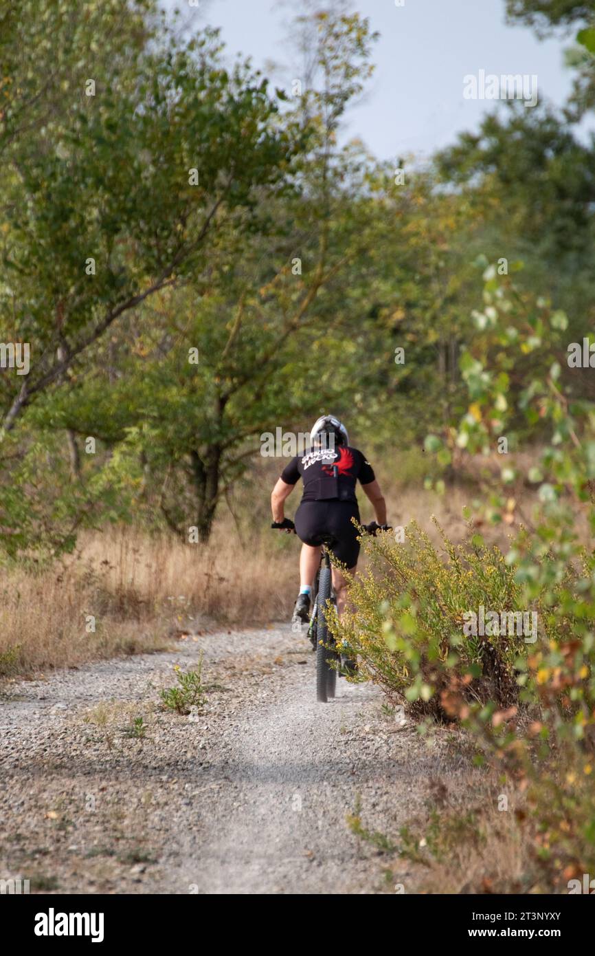 woman on a bicycle inside the park, photo taken on 10/10/2023 inside the Taro river park in Parma Italy Stock Photo