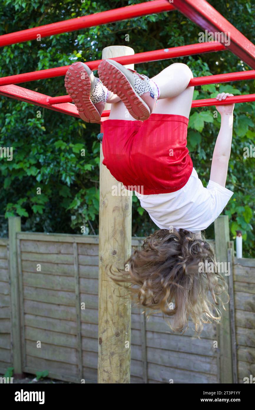 A 6 year old girl playing on the monkey bars, UK Stock Photo