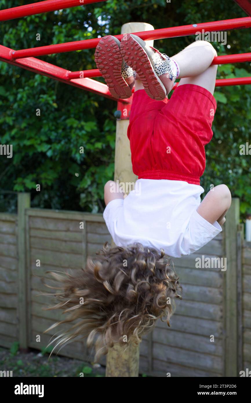 A 6 year old girl playing on the monkey bars, UK Stock Photo