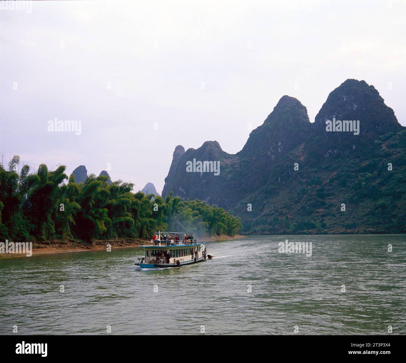 China. Guangxi Province. Li River cruise boat & Yuecheng Mountains. Stock Photo