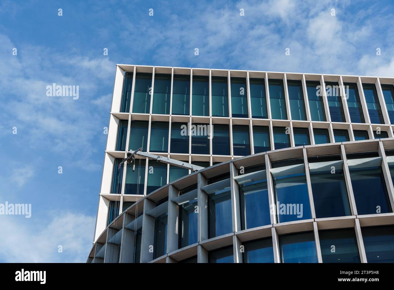 London, UK - August 25, 2023: Modern office building in the City of London. Low angle view against blue sky with white clouds. Stock Photo