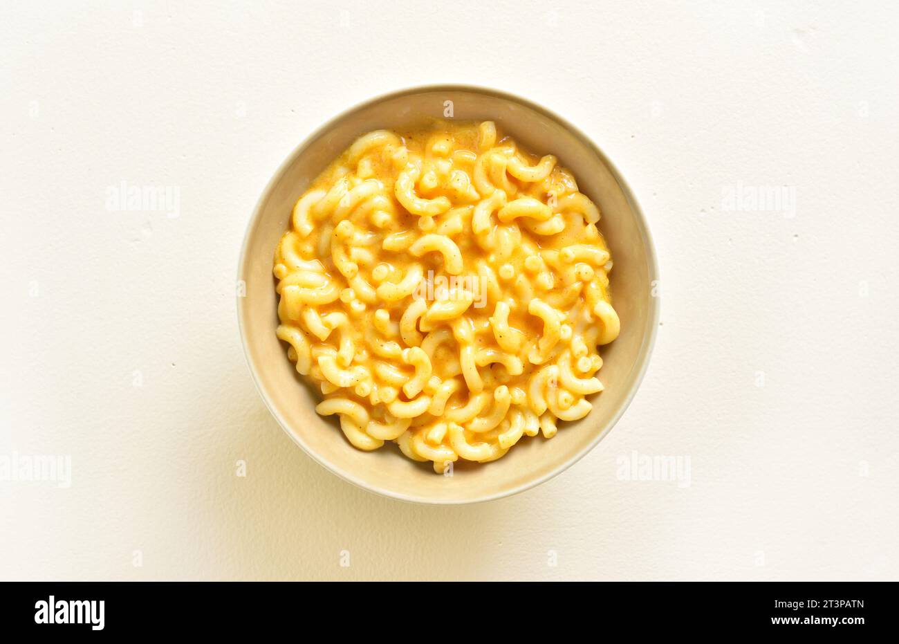 Mac and cheese in bowl over light background. Top view, flat lay Stock Photo