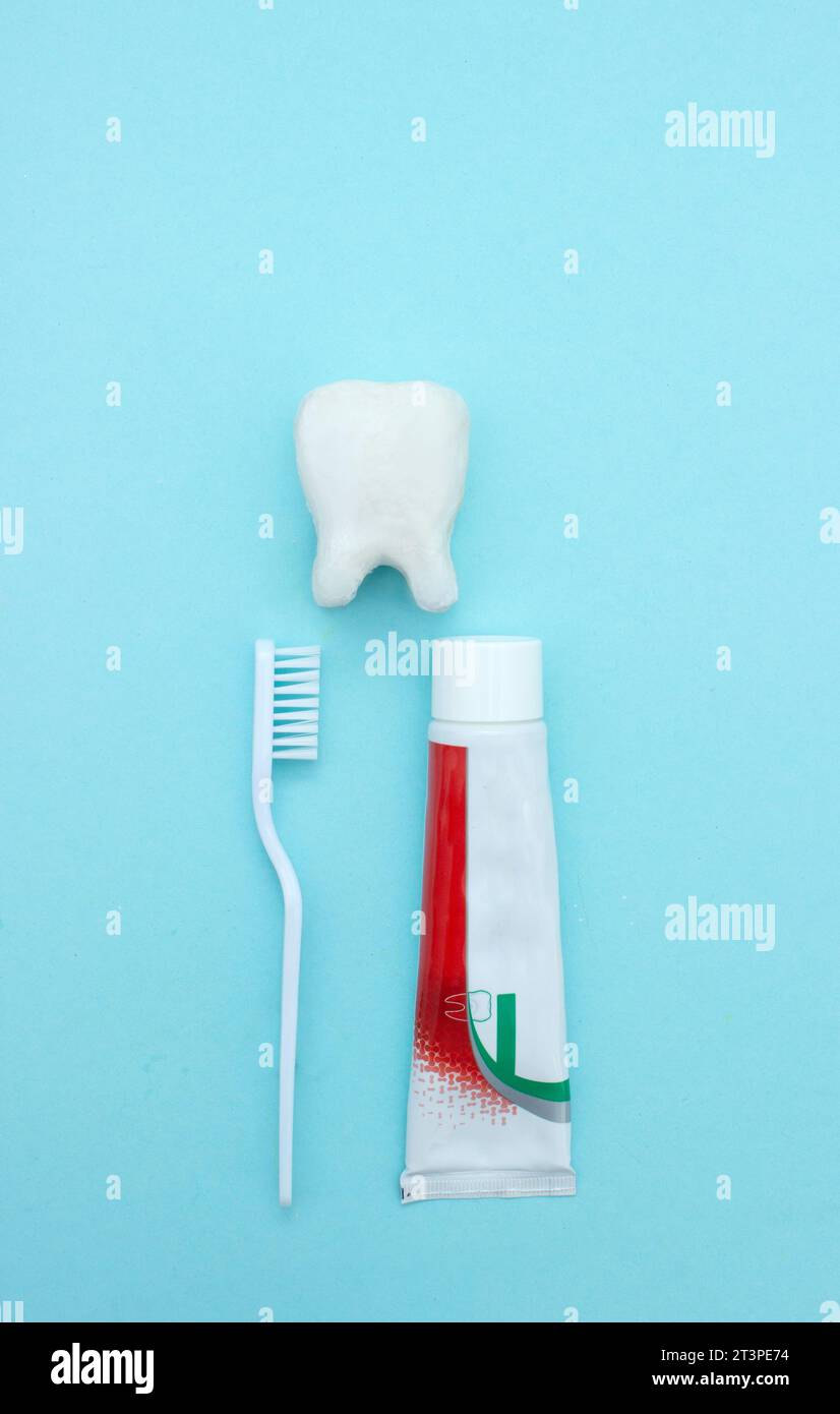 Closeup of a toothpaste, toothbrush and tooth model on blurred blue ...