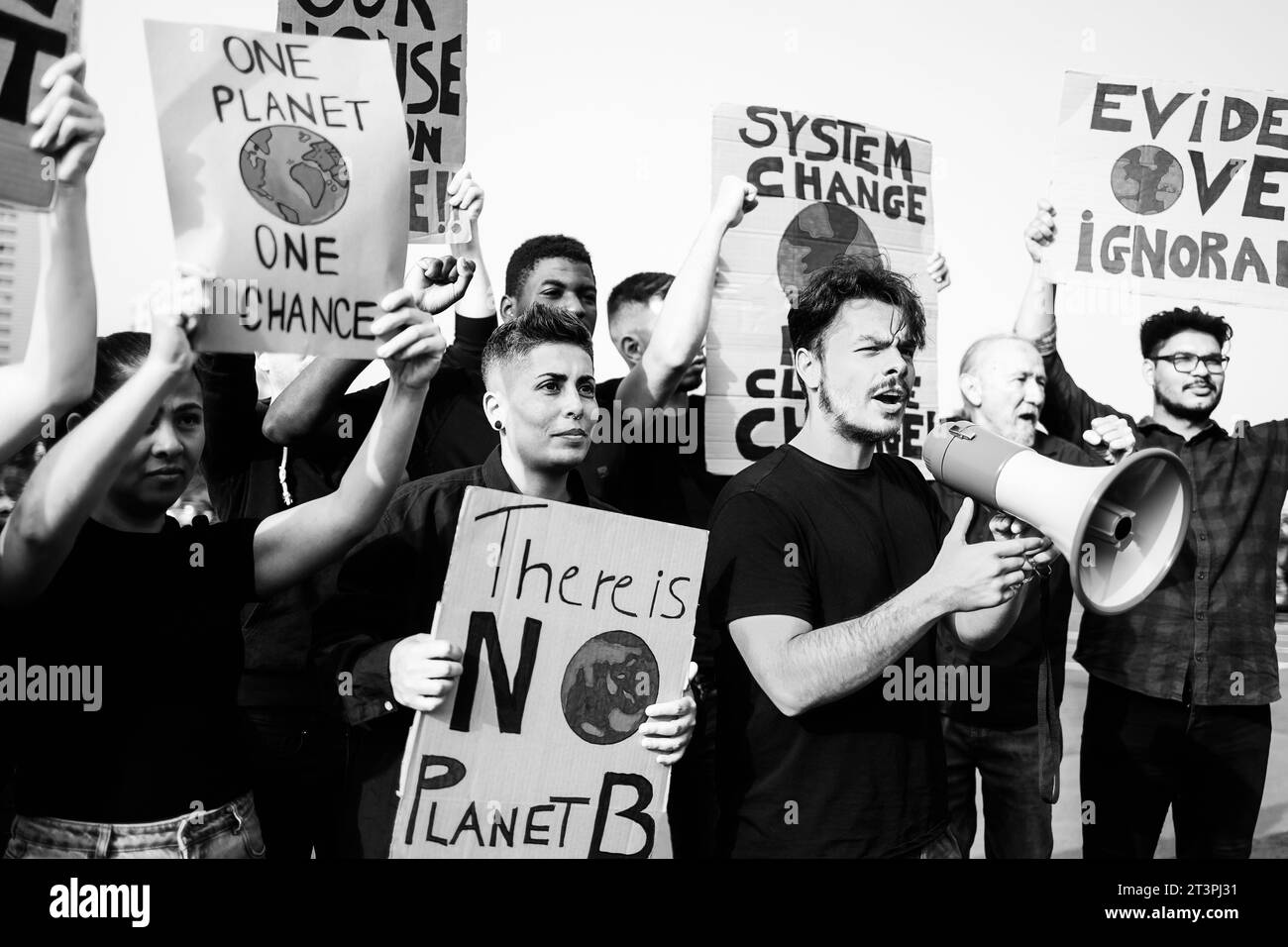 Group of people on demonstration for climate change holding banners in the city. Global warming environmental concept - Black and white editing Stock Photo
