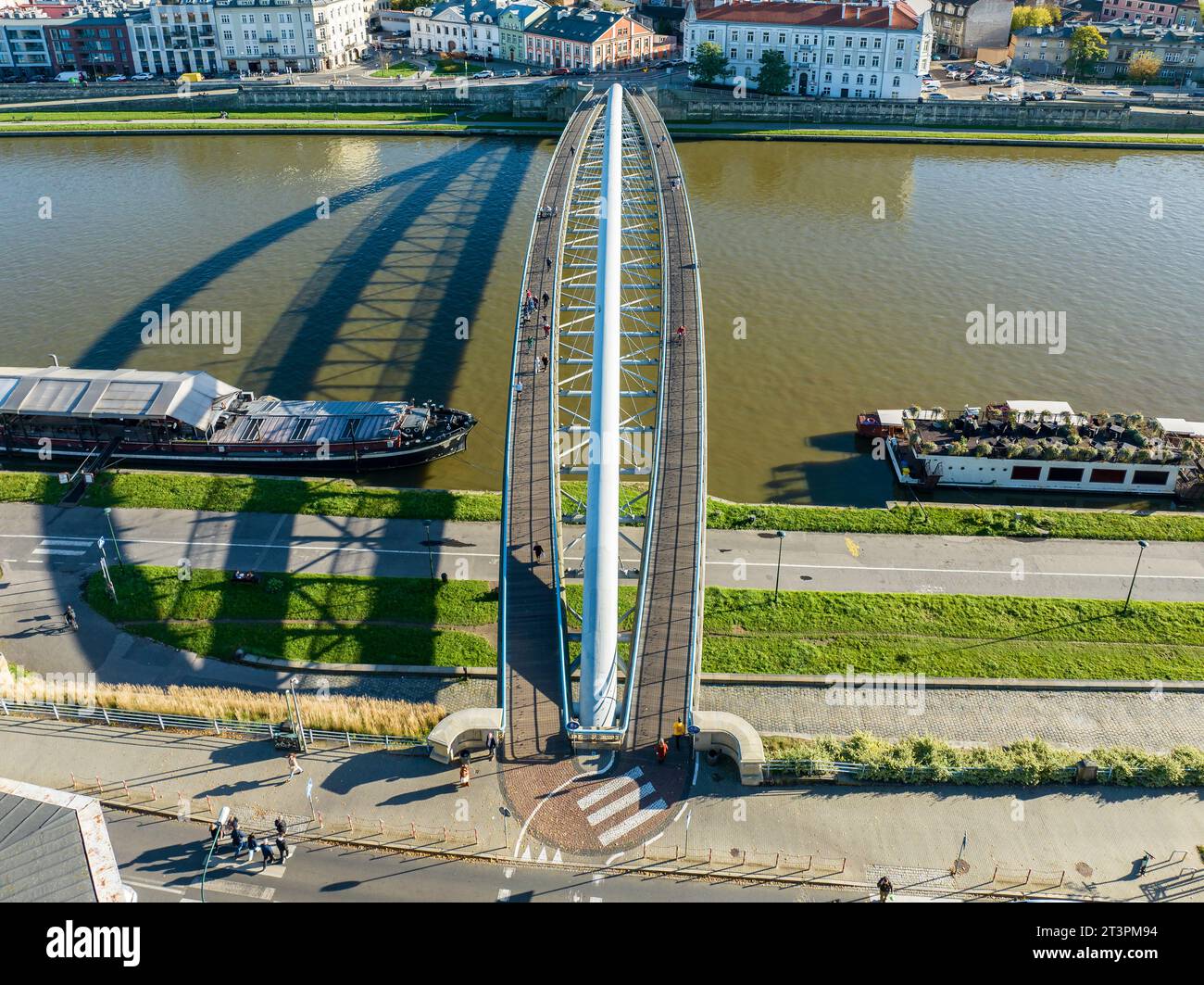 Krakow, Poland. Double suspension bridge under one arc: footbridge and bicycle bridge over Vistula River, called kladka Bernatka. Popular tourist and Stock Photo