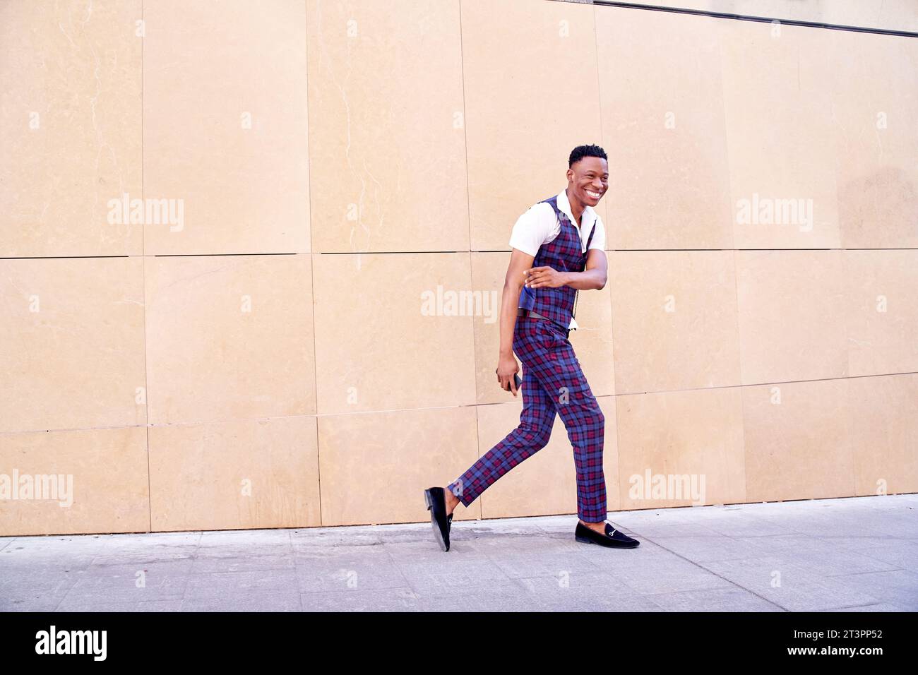 African-American man walking funny in a casual plaid suit, waistcoat and short-sleeved shirt. Stock Photo