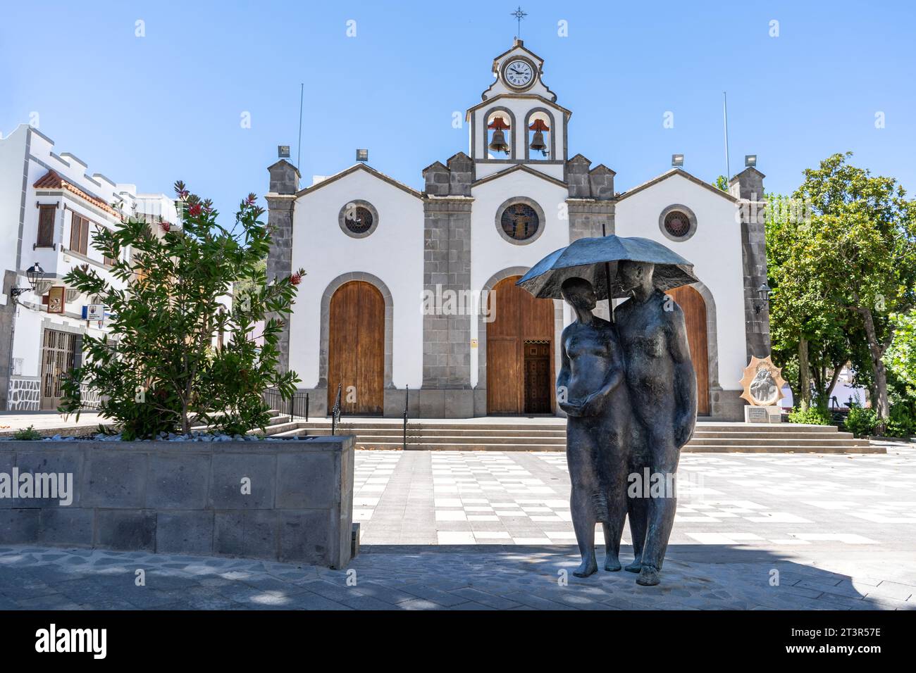 Valleseco, Spain - September 8, 2022: Sculpture called “Couple with umbrella” by Félix Reyes Arencibia in front of the church of San Vicente Ferrer, i Stock Photo